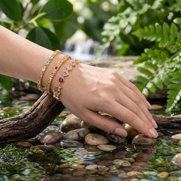Gold and gem bracelets styled on a hand
